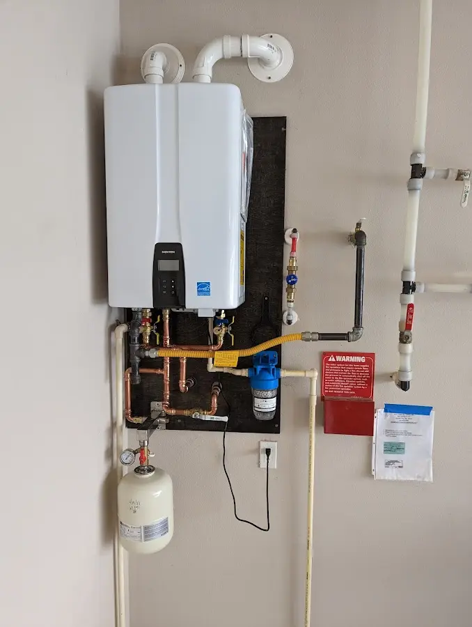 Professional plumber installing copper piping in a Little Compton home